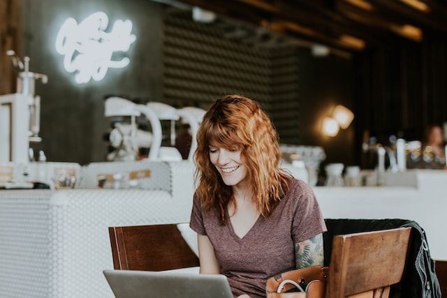 A woman playing online games on laptop.