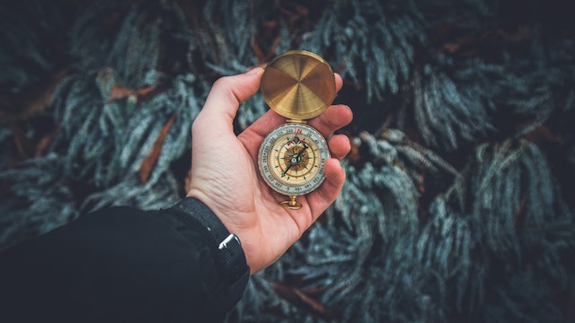 A woman holding a time watch in her hand.