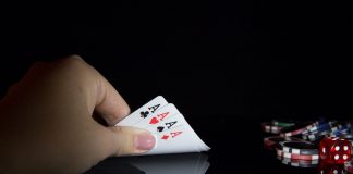 A woman holding 4 ace cards.