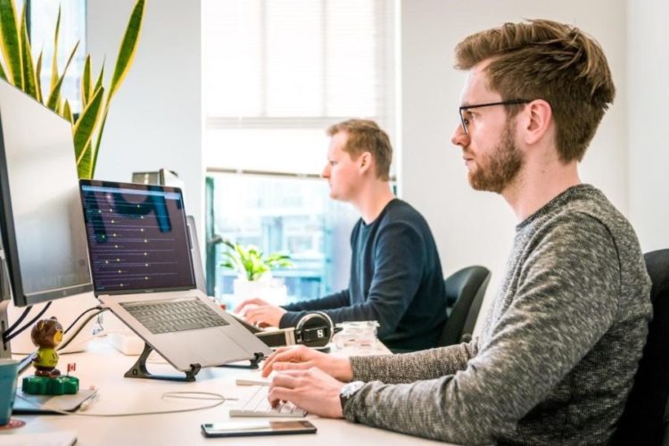 A project manager works on creating a Gantt chart on a desktop computer.